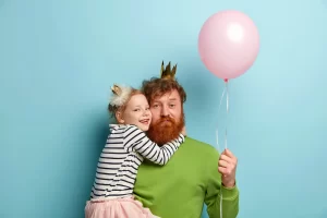 man-with-ginger-beard-his-daughter-with-party-accessories